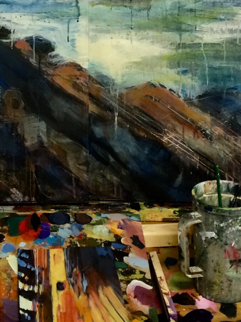 abstract landscape painting in progress with paint palette and paintbrushes