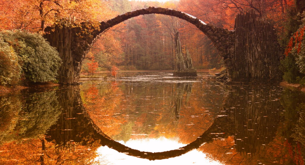 Rakotz bridge (Rakotzbrucke, Devil's Bridge) in Kromlau, Saxony, Germany. Colorful autumn, reflection of the bridge in the water create a full circle