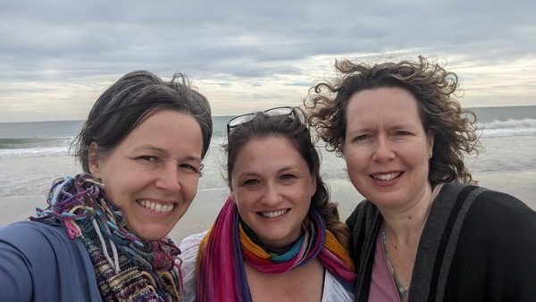 Editors Cheryl Wilder, Suzanne Farrell Smith, and Claire Guyton in front of the Atlantic ocean in North Carolina on a cool, cloudy day